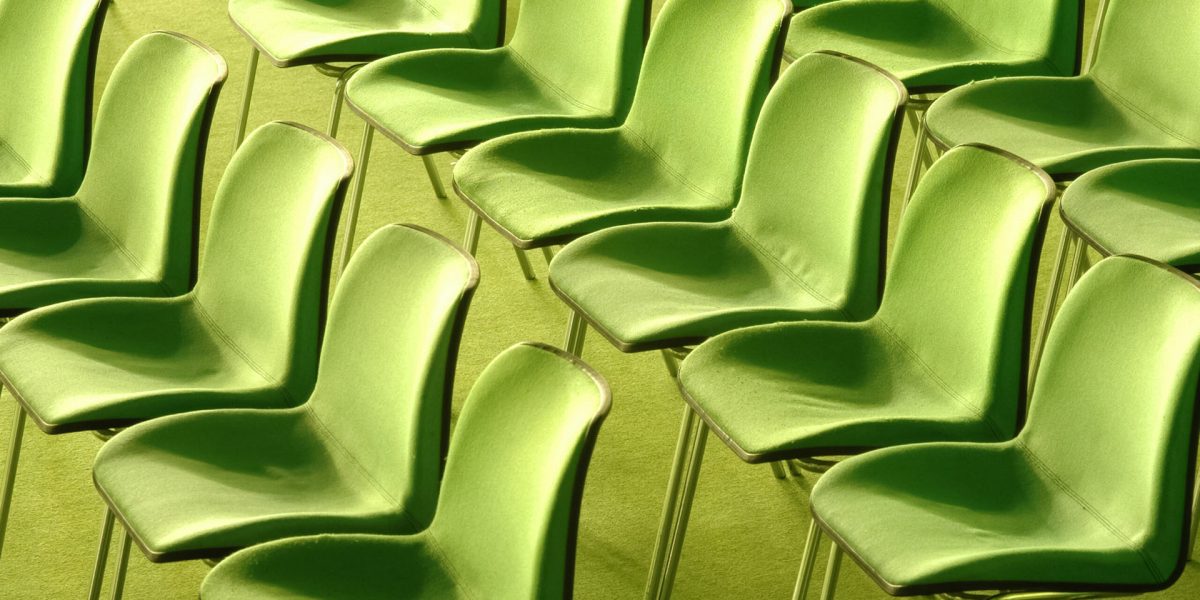 rows of green fabric chairs in a public venue
